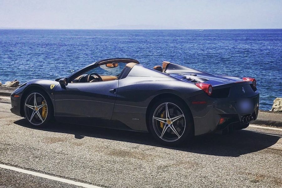 Grey Ferrari 458 Spider parked along a coastal road